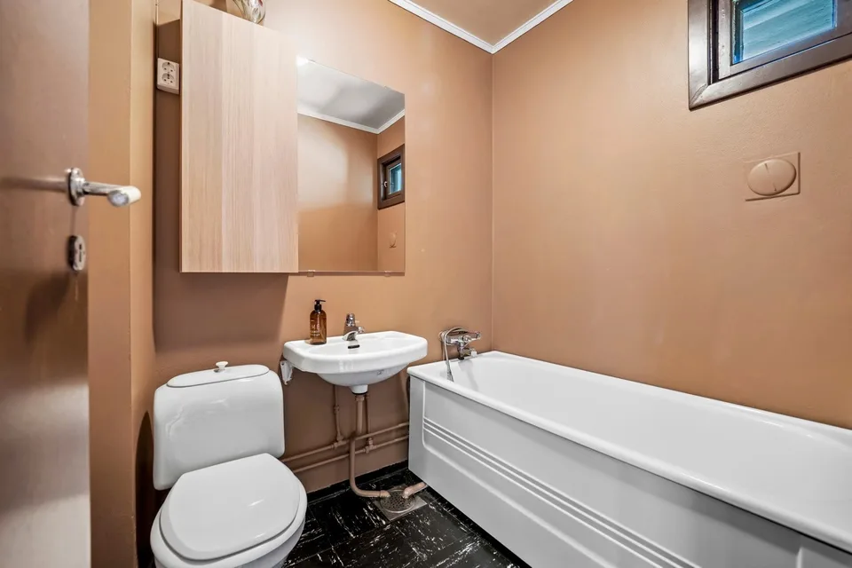 Older bathroom with a bathtub and orange walls