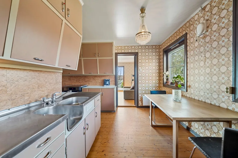 Older kitchen with patterned wallpaper and dining space