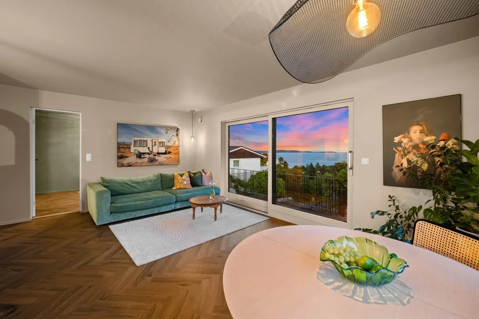 Bright renovated living room with herringbone flooring and large windows
