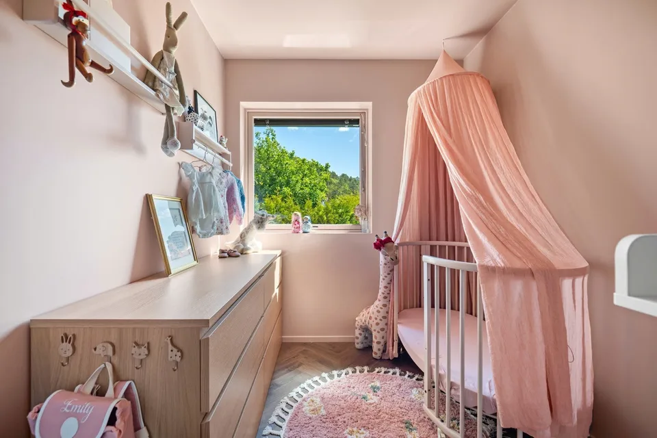 Pink nursery with a cot and canopy